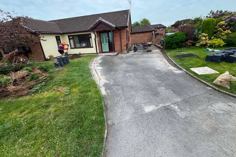 Worn grey concrete driveway leading up to a cream rendered bungalow before it was resurfaced in resin