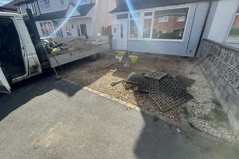 Front garden of a semi-detached house covered in loose gravel and plastic gravel grids before the new driveway