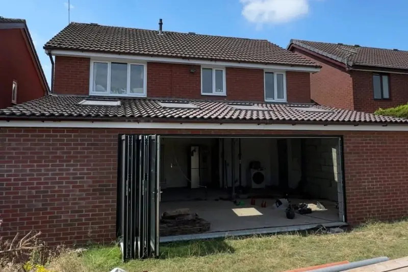 Single storey rear extension under construction with a wide opening and bifold doors folded back
