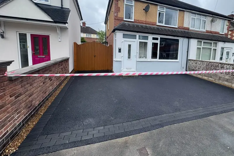 New tarmac driveway with a charcoal block paved threshold in front of a semi-detached house in Blurton, Stoke-on-Trent